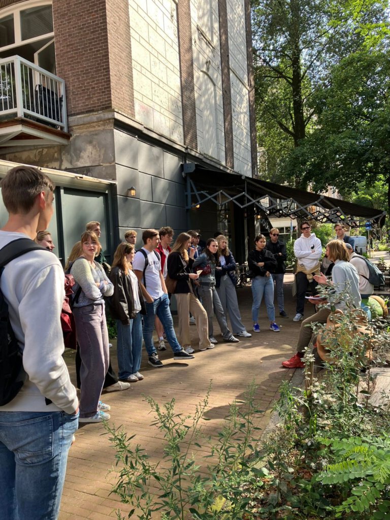 Harmen vertelt studenten van de opleiding Management van de Leefomgeving over de gemaakte ontwerpkeuzes voor het beplantingsplan in de Frans Hals buurt in Amsterdam.