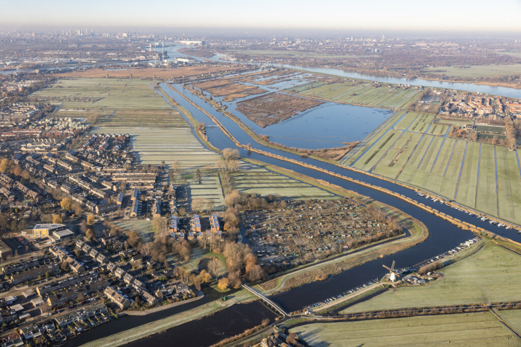 Aerial view flying above Dutch river Lek with canals near Rotterdam with view at village Papendrecht